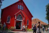 Wisatawan mancanegara mengunjungi Gereja Protestan di Indonesia bagian Barat (GPIB) Immanuel atau Gereja Merah di Probolinggo, Jawa Timur, Kamis (25/12/2025). Sedikitnya 500 pelancong kapal pesiar yang berlabuh di Pelabuhan Tanjung Tembaga mengikuti kunjungan singkat ke sejumlah destinasi wisata sejarah di Kota Probolinggo, di antaranya Gereja Merah, Kelenteng Tri Dharma Sumbernaga, dan Museum Probolinggo, dalam rangkaian wisata di kota tersebut. ANTARA Jatim/Irfan Sumanjaya/mas.