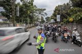 Anggota Satlantas Polres Cimahi mengatur arus lalu lintas saat pemberlakuan sistem satu arah di Lembang, Kabupaten Bandung Barat, Jawa Barat, Kamis (25/12/2025). Libur panjang Natal 2025 dan Tahun Baru 2026, Polres Cimahi memberlakukan sistem satu arah atau one way dari Kota Bandung menuju kawasan wisata Lembang dan sebaliknya secara situasional guna mengurai volume kendaraan yang terpantau padat. ANTARA FOTO/Abdan Syakura/agr