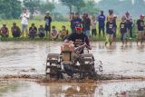 Joki beradu cepat saat lomba balap traktor di Desa Jangur, Kecamatan Sumberasih, Kabupaten Probolinggo, Jawa Timur, Jumat (26/12/2025). Pemerintah Kabupaten Probolinggo menggelar lomba balap traktor yang diikuti 32 peserta dalam rangka menyambut musim tanam sekaligus sebagai ajang promosi wisata di kawasan itu. Antara Jatim/Irfan Sumanjaya/um