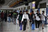 Penumpang membawa barang bawaan berjalan di Terminal Purabaya, Bungurasih, Sidoarjo, Jawa Timur, Sabtu (27/12/2025). Berdasarkan data terminal Purabaya Bungurasih, jumlah penumpang bus pada libur Natal dan Tahun Baru 2026 mencapai sekitar 42.826 orang yang terdiri dari 31.852 penumpang Antar Kota Dalam Provinsi (AKDP) dengan menggunakan 1.354 bus dan 10.974 penumpang Antar Kota Antar Provinsi (AKAP)  menggunakan 759 bus. Antara Jatim/Umarul Faruq