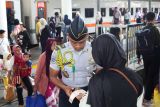 Seorang mahasiswa Politeknik Perkeretaapian Indonesia (PPI) Madiun  membantu penumpang memeriksa nomor  gerbong keretanya di Stasiun Surabaya Gubeng, Surabaya, Jawa Timur, Sabtu (27/12/2025). PT Kereta Api Indonesia (KAI) Daop 8 Surabaya mencatat pada Sabtu (27/12) hingga pukul 10.00 WIB tercatat 43.587 penumpang KA baik berangkat ataupun turun di berbagai stasiun di wilayah kerjanya, dan jumlah penumpang KA sejak awal masa angkutan Natal 2025 dan Tahun Baru 2026 pada 18 hingga 27 Desember 2025 tercatat sebanyak 454.863 penumpang. ANTARA Jatim/Didik Suhartono/mas.