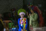 Warga menghias gadis Kasinoman Ngarot dengan mahkota bunga sebelum diarak menuju Balai Desa Lelea, Kec. Lelea, Indramayu, Jawa Barat, Rabu (31/12/2025). Perayaan pesta adat Ngarot yang diikuti puluhan remaja (kasinoman) berhiaskan bunga di kepala itu merupakan pesta menjelang musim tanam padi sebagai simbol suka cita masyarakat sebelum menggarap lahan sawah sebagai sumber pangan utama di desa itu. ANTARA FOTO/Dedhez Anggara/agr