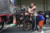 Sejumlah anggota Polri menurunkan barang bukti sepeda motor dari truk di Polrestabes Surabaya, Surabaya, Jawa Timur, Jumat (2/1/2026). Sepanjang tahun 2025 Polrestabes Surabaya beserta Polsek jajarannya berhasil mengungkap 600 kasus pencurian kendaraan bermotor (curanmor) dengan menangkap 472 tersangka dan dari jumlah tersangka itu beberapa diantara merupakan residivis. Antara Jatim/Didik Suhartono/um