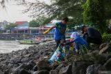 Pelajar dan warga memungut sampah di Pantai Kenjeran, Surabaya, Jawa Timur, Sabtu (3/12/2026). Tunas Hijau dan para pelajar bersama orang tuanya melakukan bersih-bersih pantai dari sampah yang berserakan di lokasi wisata pesisir pada awal tahun 2026. Antara Jatim/Didik Suhartono/um