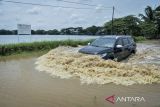 Pengendara mobil melintasi jalan yang terendam banjir di Situ Bulakan, Periuk, Kota Tangerang, Banten, Minggu (4/1/2026). Banjir setinggi 20-50 sentimeter akibat luapan air dari Situ Bulakan yang dipicu tingginya intensitas hujan dalam beberapa hari terakhir tersebut membuat akses jalan yang menghubungkan Periuk dan Kotabumi tidak bisa dilalui kendaraan roda dua. ANTARA FOTO/Putra M. Akbar/gp