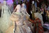 Pekerja menata busana pengantin yang dipajang saat Manten Expo di Malang, Jawa Timur, Selasa (6/1/2026). Pameran keperluan pernikahan yang berlangsung hingga Minggu (11/1) tersebut menampilkan busana pengantin tren 2026 yang didominasi warna-warna alami dan lembut, seperti sage, dusty blue, terracotta, olive, serta merah burgundy, yang memadukan elegansi modern dengan sentuhan klasik personal untuk menonjolkan kepribadian pengantin. ANTARA Jatim/Ari Bowo Sucipto/mas.