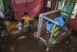 Seorang anak membersihkan perabot rumah tangga pascabanjir di Desa Tongute Ternate asal Kabupaten Halmahera Barat, Maluku Utara, Kamis (8/1/2026). Berdasarkan data sementara BPBD Kabupaten Halmahera Barat, sebanyak empat desa terdampak bencana banjir di Kecamatan Ibu yaitu Desa Gamlamo, Desa Tongute Ternate asal, Desa Gam Ici, dan Tongute Ternate serta 11 rumah rusak berat, 100 rumah rusak ringan dan 3.444 jiwa terdampak akibat banjir pada Rabu (7/1) pukul 04.00 WIT di wilayah itu. ANTARA FOTO/Andri Saputra/tom.