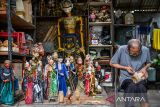 Pelestari wayang Tatang Heryana menyelesaikan produksi wayang di Galeri Ruhiyat, Bandung, Jawa Barat, Minggu (11/1/2026). Galeri Ruhiyat yang berdiri sejak 1961 oleh Alun Ruhiyat tersebut menjadi pusat edukasi seni wayang golek yang masih bertahan di Kota Bandung dengan memproduksi wayang golek serta souvenir berbentuk wayang yang diminati oleh pasar mancanegara dan berbagai kawasan wisata di Jawa Barat. ANTARA FOTO/Raisan Al Farisi/agr