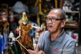 Pelestari wayang Tatang Heryana memainkan wayang yang telah selesai di produksi di Galeri Ruhiyat, Bandung, Jawa Barat, Minggu (11/1/2026). Galeri Ruhiyat yang berdiri sejak 1961 oleh Alun Ruhiyat tersebut menjadi pusat edukasi seni wayang golek yang masih bertahan di Kota Bandung dengan memproduksi wayang golek serta souvenir berbentuk wayang yang diminati oleh pasar mancanegara dan berbagai kawasan wisata di Jawa Barat. ANTARA FOTO/Raisan Al Farisi/agr