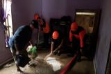 BPBD Kota Palu membantu warga bersihkan lumpur di pemukiman terdampak banjir