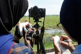 Peserta menggambar sketsa burung migran yang teramati melalui kamera dan teropong binokular saat mengikuti kegiatan Tulungagung Bird Walk #2 di area persawahan Desa Bungur, Tulungagung, Jawa Timur, Selasa (13/1/2026). Kegiatan yang melibatkan komunitas pecinta alam tersebut digelar sebagai upaya edukasi konservasi satwa burung sekaligus pengenalan keanekaragaman jenis burung, khususnya burung migran dari belahan bumi utara yang singgah di wilayah Tulungagung. ANTARA Jatim/Destyan Sujarwoko/mas.