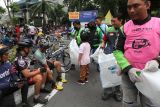 Sejumlah pengemudi ojek daring memungut sampah plastik saat Hari Bebas Kendaraan Bermotor di Jalan Darmo, Surabaya, Jawa Timur, Minggu (18/1/2026). Aksi itu dilakukan untuk menciptakan lingkungan bersih, sehat dan nyaman, serta membangun kesadaran masyarakat akan pentingnya menjaga kebersihan ruang publik. Antara Jatim/Didik Suhartono/abs