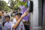 Pelajar menekan tombol lampu lalu lintas saat uji coba dan sosialisasi penggunaan Pelican Crossing di, Kota Cimahi, Jawa Barat, Senin (19/1/2026). Dinas Perhubungan (Dishub) Kota Cimahi melakukan uji coba dan sosialisasi penggunaan Pedestrian Light Controlled Crossing (Pelican Crossing) sebagai upaya menciptakan jalur aman untuk menyeberang serta mengurangi risiko kecelakaan. ANTARA FOTO/Abdan Syakura/agr