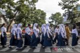 Pelajar menyeberang jalan menggunakan pelican crossing di Kota Cimahi, Jawa Barat, Senin (19/1/2026). Dinas Perhubungan (Dishub) Kota Cimahi melakukan uji coba dan sosialisasi penggunaan Pedestrian Light Controlled Crossing (Pelican Crossing) sebagai upaya menciptakan jalur aman untuk menyeberang serta mengurangi risiko kecelakaan. ANTARA FOTO/Abdan Syakura/agr