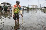 Petugas mengukur ketinggian banjir yang merendam perlintasan kereta di kawasan Kampung Bandan, Jakarta, Minggu (18/1/2026). Genangan air dampak curah hujan tinggi merendam perlintasan kereta di kawasan Kampung Bandan sehingga perjalanan KRL Cikarang Line hanya bisa dilayani sampai Stasiun Kemayoran dan Angke, serta KRL Bogor Line hanya bisa dilayani sampai Stasiun Jayakarta dan Manggarai. ANTARA FOTO/Sulthony Hasanuddin/nym. 