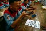 Siswa memindai kode batang (barcode) berisi formulir survei epidemiologi di SMKN 3 Boyolangu, Tulungagung, Jawa Timur, Rabu (21/1/2026). Survei epidemiologi tersebut dilakukan sebagai bagian dari penelusuran kasus gangguan pencernaan yang dialami ratusan pelajar setelah mengonsumsi makanan dari program Makan Bergizi Gratis (MBG), guna mendukung pemeriksaan laboratorium sampel makanan. ANTARA Jatim/Destyan Sujarwoko/mas.