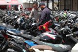 Polisi membantu warga mencari sepeda motornya saat Bazar Pengembalian Barang Bukti Sepeda Motor di Polrestabes Surabaya, Surabaya, Jawa Timur, Rabu (21/1/2026). Polrestabes Surabaya menggelar Bazar Pengembalian Barang Bukti Sepeda Motor dengan total sebanyak 1.050 sepeda motor yang diamankan dari kasus pencurian kendaraan bermotor, penggelapan kendaraan bermotor maupun balap liar sepanjang tahun 2025 dan warga  pemilik kendaraan bisa datang ke Polrestabes Surabaya pada 21-23 Januari 2026 dan 26-30 JanuariÂ  2026 dengan membawa dokumen lengkap kendaraannya. ANTARA Jatim/Didik Suhartono/mas.