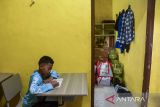Siswa mengikuti kegiatan belajar mengajar di tempat istirahat wali asuh di Sekolah Rakyat Terintegrasi 41 Tasikmalaya, Jawa Barat, Rabu (21/1/2026). Sebanyak tujuh siswa tingkat SMP dan 11 siswa tingkat SD terpaksa melaksanakan kegiatan belajar mengajar di gudang atau tempat istirahat wali asuh dan tenaga kependidikan sekolah serta mushola akibat kekurangan ruang kelas. ANTARA FOTO/Adeng Bustomi/agr