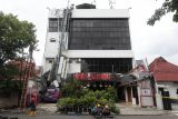 Menara Base Transceiver Station (BTS) roboh menjuntai ke bawah di gedung SHS di Jalan Joyoboyo, Surabaya, Jawa Timur, Jumat (23/1/2026). Menara itu roboh dan mejuntai di atap gedung SHS diduga disebabkan angin kencang. Antara Jatim/Didik Suhartono/abs
