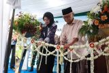 Pengasuh Pondok Pesantren Al Amien sekaligus Ketua Umum Majelis Ulama Indonesia (MUI) KH Anwar Iskandar (kanan) dan Wali Kota Kediri Vinada Prameswati (kiri) menggunting rangkaian bunga saat peluncuran Satuan Pelayanan Pemenuhan Gizi (SPPG) 2 Pondok Pesantren Al Amien, Kota Kediri, Jawa Timur, Jumat (23/1/2026). Pondok pesantren Al Amien menambah SPPG guna melayani makan bergizi gratis (MBG) untuk 3.200 penerima manfaat setelah sebelumnya meluncurkan SPPG 1 yang diharapkan mampu memberikan asupan gizi berkualitas kepada santri dan pelajar sekaligus pemberdayaan ekonomi lokal. Antara Jatim/Prasetia Fauzani/abs