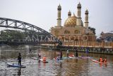 Sejumlah peserta menaiki selancar dayung atau paddle board saat memungut sampah di aliran Sungai Karang Mumus, Samarinda, Kalimantan Timur, Minggu (25/1/2026). Puluhan anggota yang tergabung dalam komunitas Paddle Board Samarinda tersebut menyusuri Sungai Karang Mumus sepanjang 6,6 kilometer untuk membersihkan sampah yang berada di aliran sungai sebagai upaya pencegahan banjir. Antara Kaltim/M Risyal Hidayat