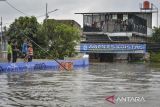 Anak-anak mengukur kedalaman banjir menggunakan bambu di Periuk, Kota Tangerang, Banten, Jumat (23/1/2026). Banjir setinggi 50 centimeter hingga dua meter tersebut akibat luapan Kali Ledug dan jebolnya tanggul. ANTARA FOTO/Putra M. Akbar/gp