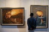 Pengunjung mengamati lukisan pada pameran bertema Mangsa Kalasubo di Galeri Dewan Kesenian Surabaya, kompleks Balai Pemuda Surabaya, Surabaya, Jawa Timur, Jumat (30/1/2026). Lesbumi PWNU Jawa Timur menggelar pameran dengan menampilkan 16 lukisan karya 15 perupa untuk menyambut harlah Nahdlatul Ulama. Antara Jatim/Didik Suhartono/abs