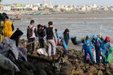 Sejumlah pelajar memungut sampah di Pantai Kenjeran, Surabaya, Jawa Timur, Sabtu (31/1/2026). Aksi kolaboratif anggota Tunas Hijau bersama para pelajar dan orang tua mereka tersebut dilakukan guna menjaga kebersihan lingkungan kawasan wisata dari sampah, khususnya limbah plastik, sehingga tercipta suasana yang bersih dan nyaman bagi masyarakat maupun wisatawan. Antara Jatim/Didik Suhartono/abs