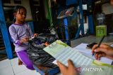 Petugas mencatat hasil tabungan sampah seorang anak di Bank Sampah One Six Sauyunan di Astanaanyar, Bandung, Jawa Barat, Senin (9/2/2026). Kementerian Lingkungan Hidup melalui Badan Pengendalian Lingkungan Hidup mencanangkan program satu RW satu bank sampah yang menjadi program strategis nasional dan diharapkan mampu mengoptimalkan pengelolaan sampah melalui pemberdayaan masyarakat dengan menargetkan sebanyak 83.451 bank sampah baru pada 2029 mendatang. ANTARA FOTO/Raisan Al Farisi/agr