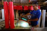 Seorang pekerja membuat sablon untuk plastik kemasan merek lilin sembahyang hasil produksi industri rumahan milik Susanto di Desa Punggur Kecil, Kecamatan Sungai Kakap, Kabupaten Kubu Raya, Kalimantan Barat, Senin (9/2/2026). Usaha pembuatan lilin yang telah berjalan selama 15 tahun tersebut memproduksi lilin sembahyang untuk klenteng dengan ukuran mulai dari kecil hingga mencapai setinggi dua meter, dengan harga dari ribuan hingga jutaan rupiah per pasang yang dipasarkan di wilayah Kalimantan Barat. ANTARA FOTO/Jessica Wuysang