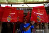 Seorang pekerja menjemur plastik kemasan merek lilin sembahyang hasil sablon produksi industri rumahan milik Susanto di Desa Punggur Kecil, Kecamatan Sungai Kakap, Kabupaten Kubu Raya, Kalimantan Barat, Senin (9/2/2026). Usaha pembuatan lilin yang telah berjalan selama 15 tahun tersebut memproduksi lilin sembahyang untuk klenteng dengan ukuran mulai dari kecil hingga mencapai setinggi dua meter, dengan harga dari ribuan hingga jutaan rupiah per pasang yang dipasarkan di wilayah Kalimantan Barat. ANTARA FOTO/Jessica Wuysang