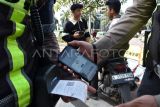 Personel Sat Lantas Polresta Bogor Kota menggunakan alat tilang Electronic Traffic Law Enforcement (ETLE) Mobile pada pelanggar lalu lintas yang tidak menggunakan helm di depan Tugu Kujang, Kota Bogor, Jawa Barat, Rabu (11/2/2026). Penggunaan alat tilang ETLE Mobile tersebut untuk memudahkan dan menindak pelanggaran secara langsung selama Operasi Keselamatan Lodaya 2026 yang mendeteksi pelanggaran lalu lintas seperti parkir sembarangan, pelanggaran rambu dan tidak menggunakan helm dengan bukti struk yang tercetak. ANTARA FOTO/Arif Firmansyah/foc. 