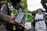 Personel Sat Lantas Polresta Bogor Kota menggunakan alat tilang Electronic Traffic Law Enforcement (ETLE) Mobile pada pelanggar lalu lintas yang tidak menggunakan helm di depan Tugu Kujang, Kota Bogor, Jawa Barat, Rabu (11/2/2026). Penggunaan alat tilang ETLE Mobile tersebut untuk memudahkan dan menindak pelanggaran secara langsung selama Operasi Keselamatan Lodaya 2026 yang mendeteksi pelanggaran lalu lintas seperti parkir sembarangan, pelanggaran rambu dan tidak menggunakan helm dengan bukti struk yang tercetak. ANTARA FOTO/Arif Firmansyah/foc.