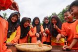 Sejumlah siswa bermain gasing bambu di SDN 1 Pesucen, Kalipuro, Banyuwangi, Jawa Timur, Sabtu (14/2/2026). Kegiatan permainan tradisional antara sekolah Adat Kampung Baca Taman Rimba (Batara) dan Sekolah formal tersebut menjadi upaya melestarikan budaya lokal, sekaligus mengembangkan kemampuan motorik, kerja sama, serta karakter Sosial peserta didik. Antara Jatim/Budi Candra Setya/abs