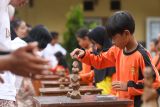 Seorang siswa menata balok kayu pada permainan pateng dudu di SDN 1 Pesucen, Kalipuro, Banyuwangi, Jawa Timur, Sabtu (14/2/2026). Kegiatan permainan tradisional antara sekolah Adat Kampung Baca Taman Rimba (Batara) dan Sekolah formal tersebut menjadi upaya melestarikan budaya lokal, sekaligus mengembangkan kemampuan motorik, kerja sama, serta karakter Sosial peserta didik. Antara Jatim/Budi Candra Setya/abs
