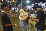 Pengunjung (tengah) memegang ular piton (Python reticulatus) milik komunitas Gubuk Oray Galak pada pameran satwa di Jambi, Jumat (13/2/2026). Kegiatan yang berlangsung mulai 13-16 Februari dengan tujuan mengedukasi pengunjung tersebut menampilkan beberapa satwa di antaranya, ayam serama (Gallus gallus domesticus), buldog, dan beberapa jenis ikan. ANTARA FOTO/Wahdi Septiawan/aww.