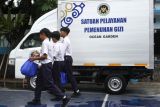 Siswa piket membawa Makan Bergizi Gratis (MBG) menuju ke kelasnya untuk dibagikan di SMPN 6 Malang, Jawa Timur, Selasa (24/2/2026).  Menu MBG berupa paket kering yang dibagikan pada hari keenam bulan Ramadhan tersebut terdiri atas keju, buah salak, kacang, kurma dan roti abon yang diperuntukkan bagi 797 siswa serta 48 guru dan tenaga kependidikan di sekolah tersebut. Antara Jatim. Ari Bowo Sucipto