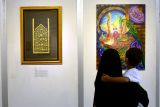 Pengunjung melihat lukisan kaligrafi yang dipamerkan dalam pameran kaligrafi bertajuk Ziarah Jiwa di Blitar Art Center, Kota Blitar, Jum'at (27/2/2026). Pameran tersebut memamerkan 32 lukisan kaligrafi karya 13 seniman asal Blitar, Kediri dan beberapa kota disekitarnya sebagai upaya memberikan ruang untuk ekspresi melalui seni rupa, sekaligus ajang silaturahmi para seniman di bulan Ramadhan. Antara Jatim/Irfan Anshori/abs