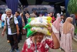 Warga menyunggi beras SPHP yang dibelinya pada Pasar Murah Ramadhan di Kalibaru, Banyuwangi, Jawa Timur, Sabtu (28/2/2026). Pemerintah Provinsi Jawa Timur menggelar 110 titik pasar murah di berbagai kota/Kabupaten di Jawa Timur untuk menjaga daya beli masyarakat selama Bulan Ramadhan. ANTARA Jatim/Budi Candra Setya/mas.
