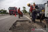 Pekerja melakukan penambalan jalan di jalur Pantura Widasari, Indramayu, Jawa Barat, Senin (2/3/2026). Menteri Pekerjaan Umum (PU) Dody Hanggodo memastikan perbaikan jalan di jalur Pantura selesai pada pada H-10 Lebaran guna memberikan kenyamanan pengendara dan mencegah kecelakaan saat arus mudik. ANTARA FOTO/Dedi Suwidiantoro/agr