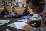 Petugas melayani warga yang melakukan daftar ulang mudik gratis Lebaran 2026 di kantor Dishub Kota Cimahi, Jawa Barat, Senin (9/3/2026). Pemkot Cimahi menyediakan kuota mudik gratis untuk 720 pemudik dengan tujuan Cirebon, Semarang, Solo, dan Yogyakarta yang dijadwalkan berangkat pada 18 Maret 2026. ANTARA FOTO/Abdan Syakura/agr