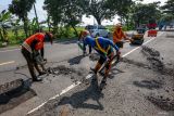 Pekerja melakukan perbaikan jalan di ruas jalan nasional Nganjuk, Jawa Timur, Senin (9/3/2026). Balai Besar Pelaksanaan Jalan Nasional (BBPJN) Jawa Timur - Bali melakukan perbaikan jalan nasional di Jawa Timur dengan pengaspalan dan pengecoran di sekitar 14.132 titik lubang yang terdata sepanjang 2.261,68 kilometer yang ditargetkan rampung pada H-10 Lebaran guna memberikan keamanan dan kenyamanan bagi pengendara saat arus mudik Idul Fitri 1447 H. ANTARA Jatim/Muhammad Mada/mas.