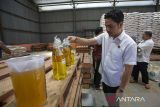 Petugas dari Satgas Pangan memeriksa minyak goreng bantuan pangan yang akan disalurkan di gudang Bulog Indramayu, Jawa Barat, Rabu (11/3/2026). Bulog cabang Indramayu memastikan kesiapannya dalam menyalurkan bantuan pangan beras kepada 314.129 penerima bantuan pangan (PBP) periode Februari - Maret untuk menjaga stabilitas ekonomi masyarakat berpenghasilan rendah dan menekan inflasi pangan. ANTARA FOTO/Dedi Suwidiantoro/agr