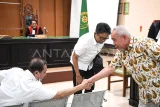 Gubernur Kalimantan Timur periode 2018-2023 Isran Noor (kanan) menyalami terdakwa Zairin Zain (kiri) dan disaksikan terdakwa Agus Hari Kesuma (kedua kiri) seusai sidang lanjutan kasus dugaan korupsi dana hibah Desain Besar Olahraga Nasional (DBON) Kalimantan Timur di Pengadilan Negeri Samarinda, Kalimantan Timur, Selasa (10/3/2026). Sidang beragendakan mendengarkan keterangan dua saksi yang dihadirkan Jaksa Penuntut Umum (JPU), yakni Isran Noor dan Penjabat (Pj) Sekda Kaltim Riza Indra Riadi. Antara Kaltim/M Risyal Hidayat