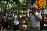 Umat Hindu memikul sesaji berisi aneka hasil bumi dalam rangkaian ritual Melasti di kawasan konservasi Telaga Buret, Tulungagung, Jawa Timur, Minggu (15/3/2026). Ritual tersebut digelar sebagai rangkaian perayaan Hari Raya Nyepi Tahun Baru Saka 1948 yang dimaknai sebagai prosesi penyucian diri dan sarana upacara umat Hindu untuk membersihkan diri secara lahir dan batin sebelum memasuki Tahun Baru Saka. ANTARA Jatim/Destyan Sujarwoko/mas.