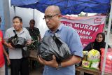 Warga membeli paket sembako berharga murah di Koperasi Kelurahan Merah Putih (KKMP) Ngronggo, Kota Kediri, Jawa Timur, Rabu (18/3/2026). Program tebus murah kebutuhan pokok meliputi beras SPHP kemasan 5 kilogram, gula pasir 1 kilogram, minyak goreng 1 liter, mie instan 4 bungkus seharga Rp100 ribu per pakat dan gratis takjil tersebut guna membantu masyarakat mendapatkan kebutuhan pokok terjangkau menjelang Lebaran sekaligus sebagai upaya menarik anggota baru KKMP. ANTARA Jatim/Prasetia Fauzani/mas.