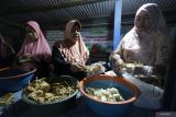 Warga memotong ketupat saat tradisi Grebeg Ketupat di Desa Sidomulyo, Kabupaten Kediri, Jawa Timur, Kamis (26/3/2026). Tradisi grebeg ketupat dengan menyediakan empat gunungan berisi sedikitnya 1.500 ketupat dari swadaya masyarakat tersebut guna menyongsong lebaran ketupat yang dirayakan warga setempat pada hari ke tujuh Idul Fitri. Antara Jatim/Prasetia Fauzani/abs