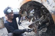Mengumpulkan onderdil dari mobil yang dibakar pendemo