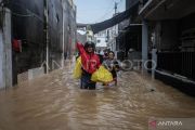 Warga Manado sedang melintasi banjir