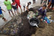 Nelayan menjaring sampah laut di Padang